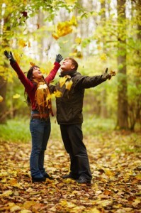 Autumn - Happy couple enjoying falling leaves